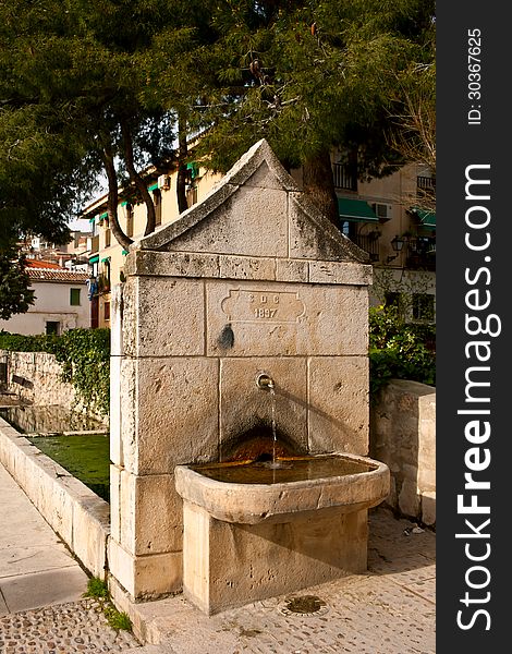 Old water fountain in the street of Chinchon, Madrid, Spain