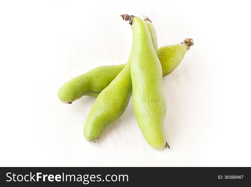 Broad beans in a pod on a white background