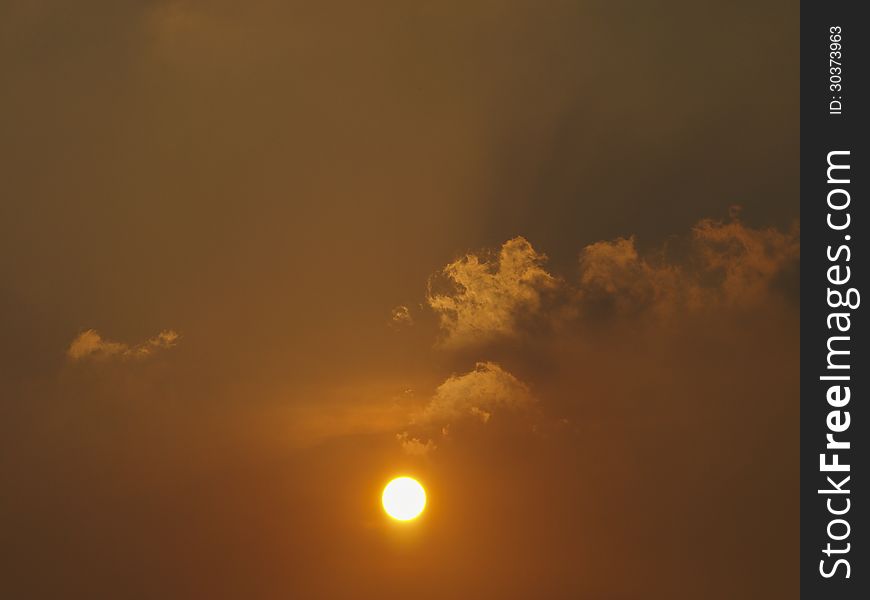 View of orange sun in orange sky with cloud. View of orange sun in orange sky with cloud