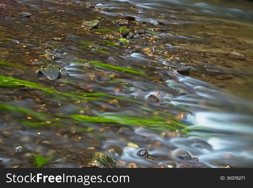 Flowing water with rocks in the creek. Flowing water with rocks in the creek