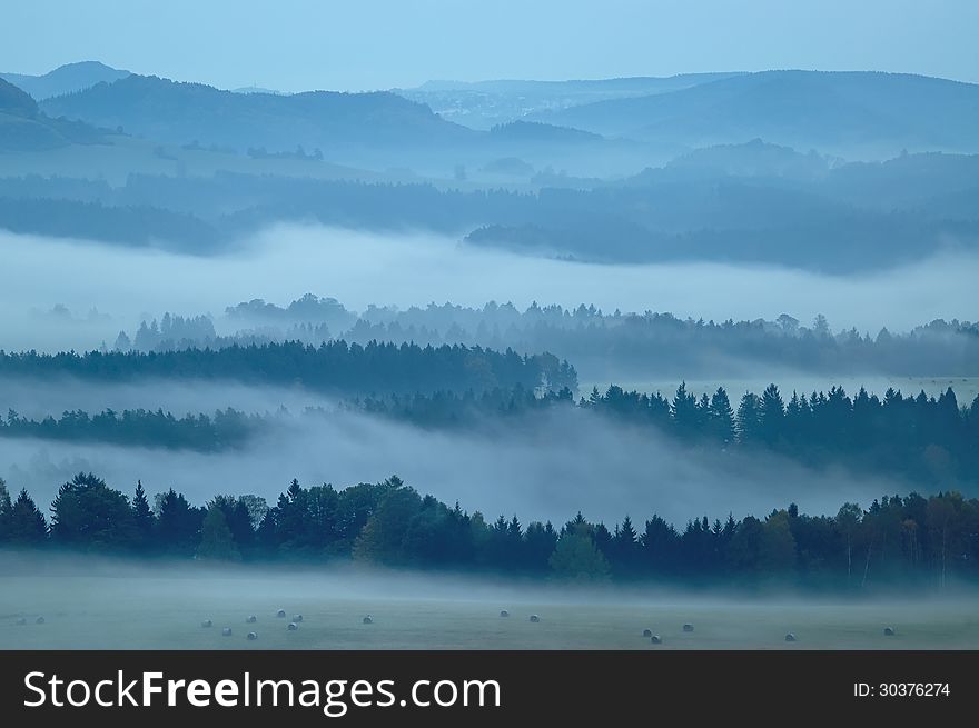 Autumn morning hilly landscape with fog