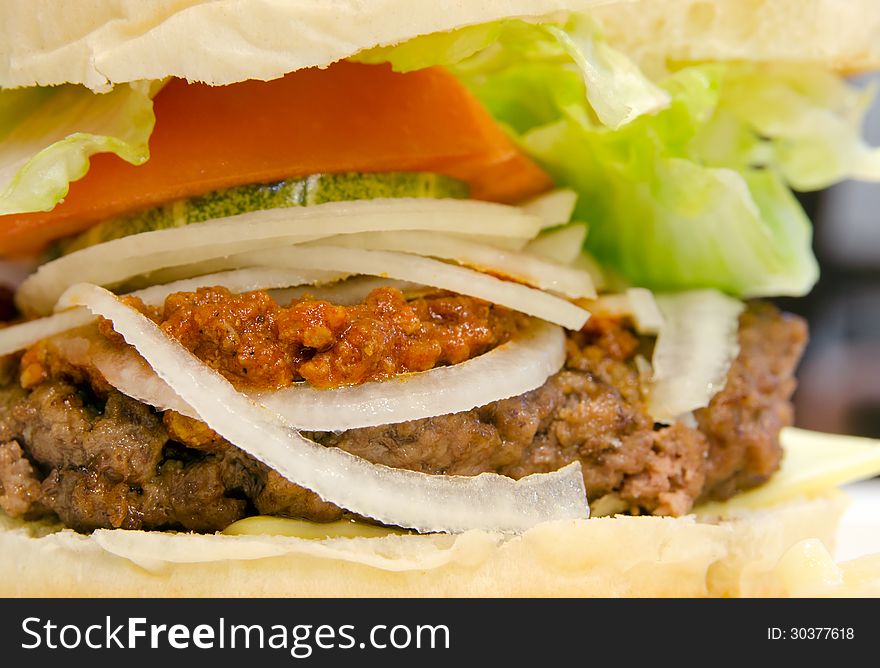 American style chili burger with onions and greens