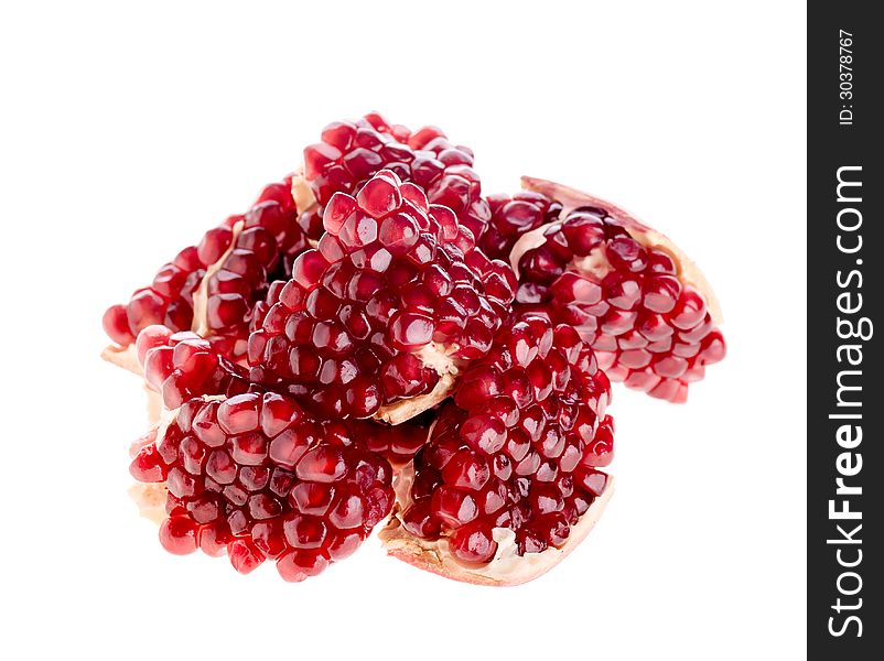 Pieces of the pomegranate fruit folded a heap on the white background