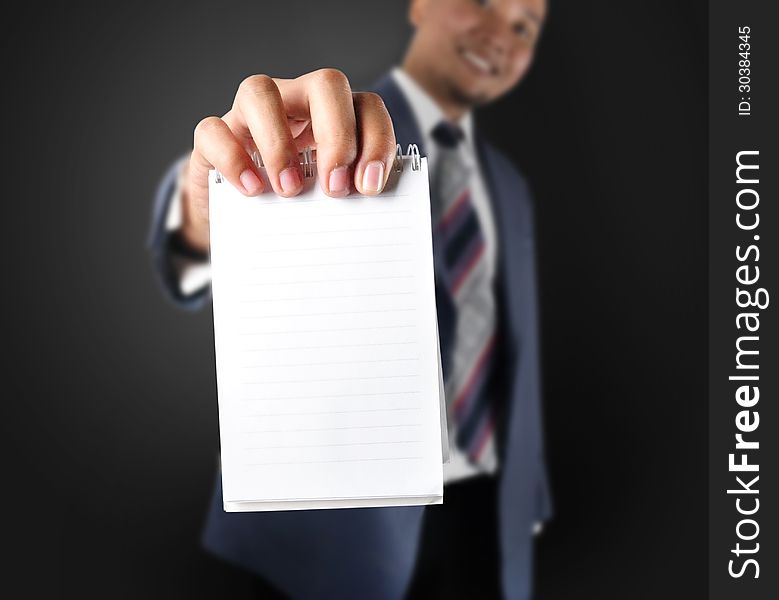 Business man showing note paper. With dark background