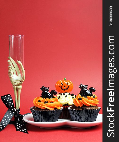 Halloween party food with skeleton hand glass on red background - vertical with copyspace.