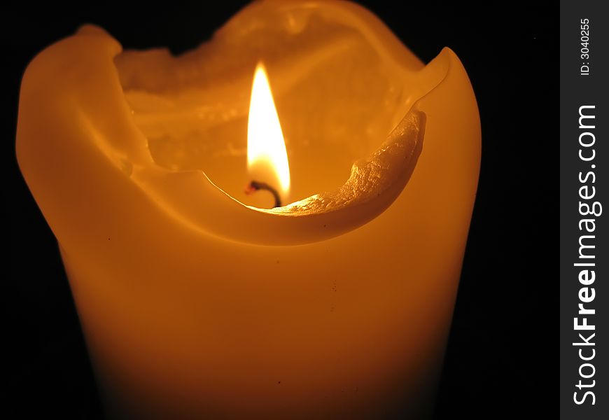 Burning candle in dark church