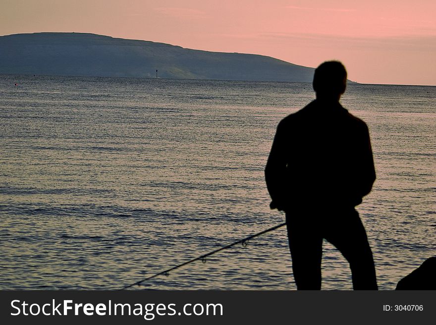 Fisherman on the Rocks in Galway Bay Fishing at dusk. Fisherman on the Rocks in Galway Bay Fishing at dusk