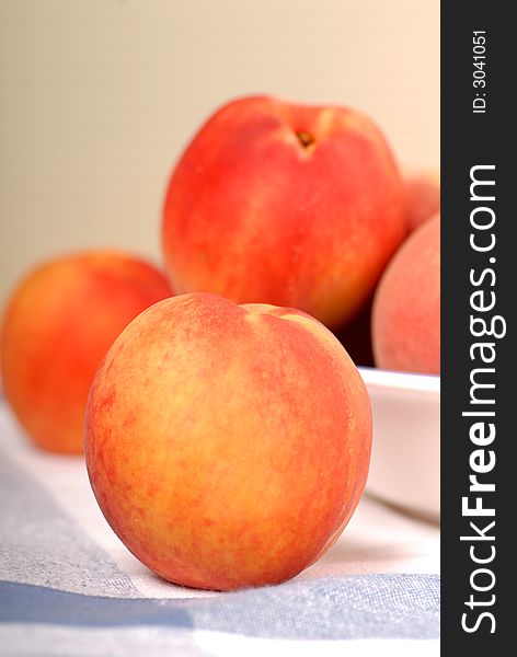 A white bowl containing fresh ripe peaches. A white bowl containing fresh ripe peaches