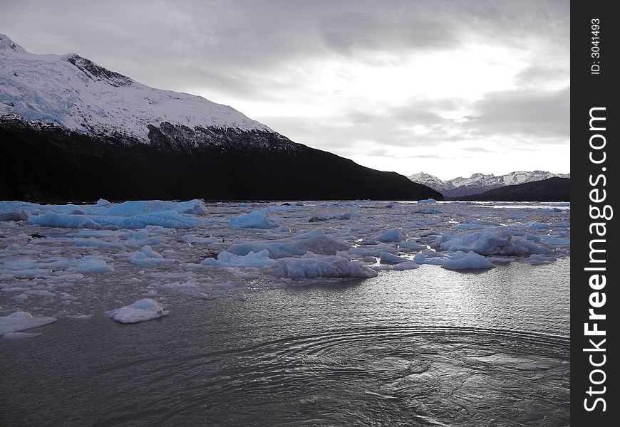 Floating icebergs surrounded by mountains in Argentina Lake