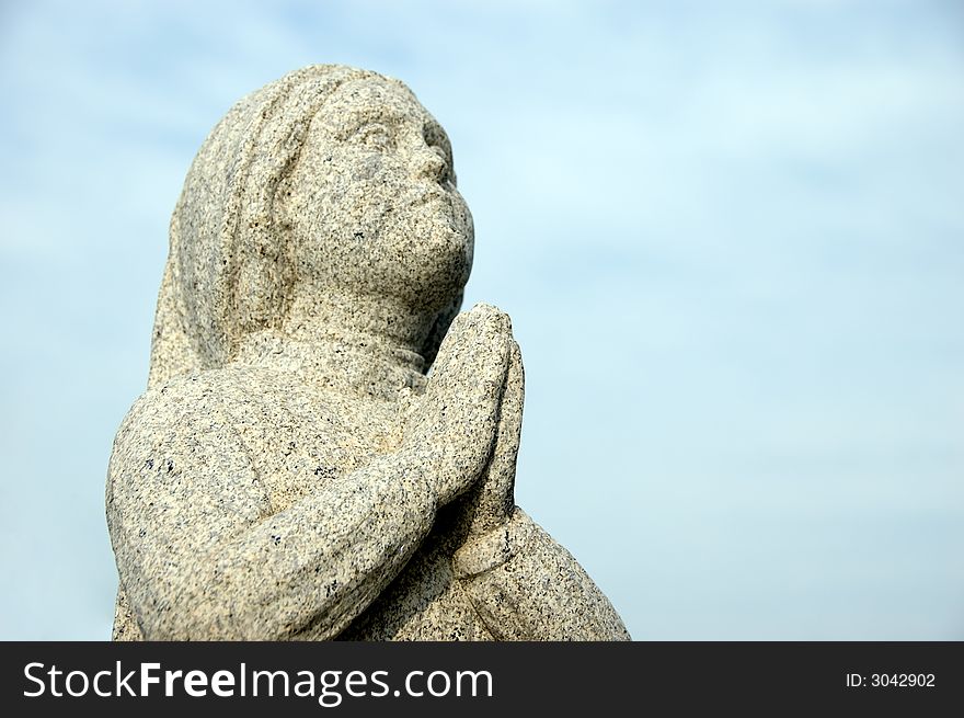 Praying statue with focus on hands