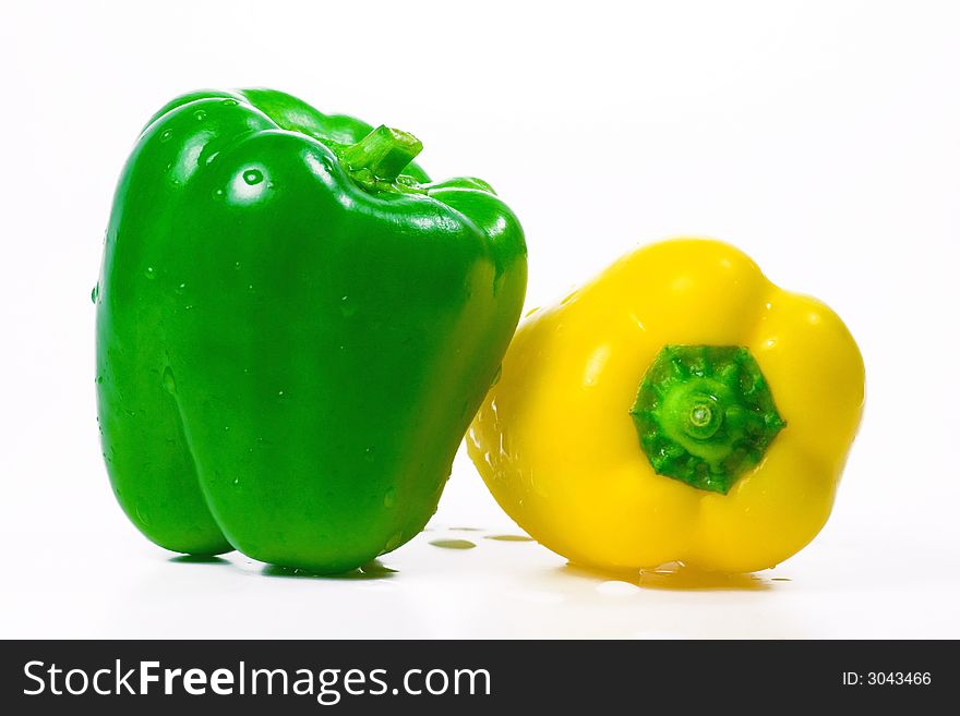 The isolated green and yellow pepper with drops of water. The isolated green and yellow pepper with drops of water