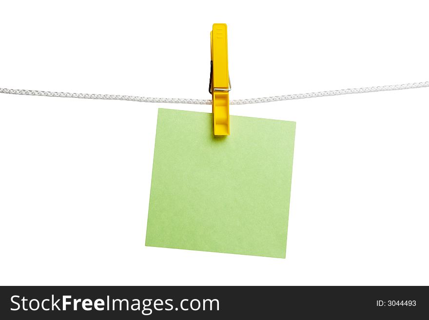 Green paper on yellow clothespin hanging on a cord isolated on a white background