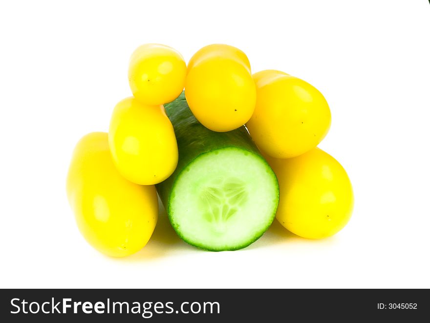 Cut half of a cucumber with yellow tomatoes on top isolated on white. Cut half of a cucumber with yellow tomatoes on top isolated on white