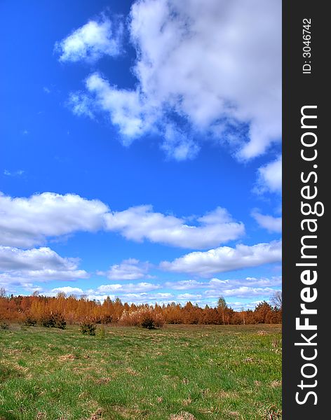 Autumn landscape with white clouds on blue sky