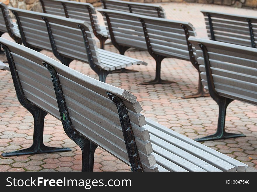 Rows of benches set up for outdoor viewing of a stage