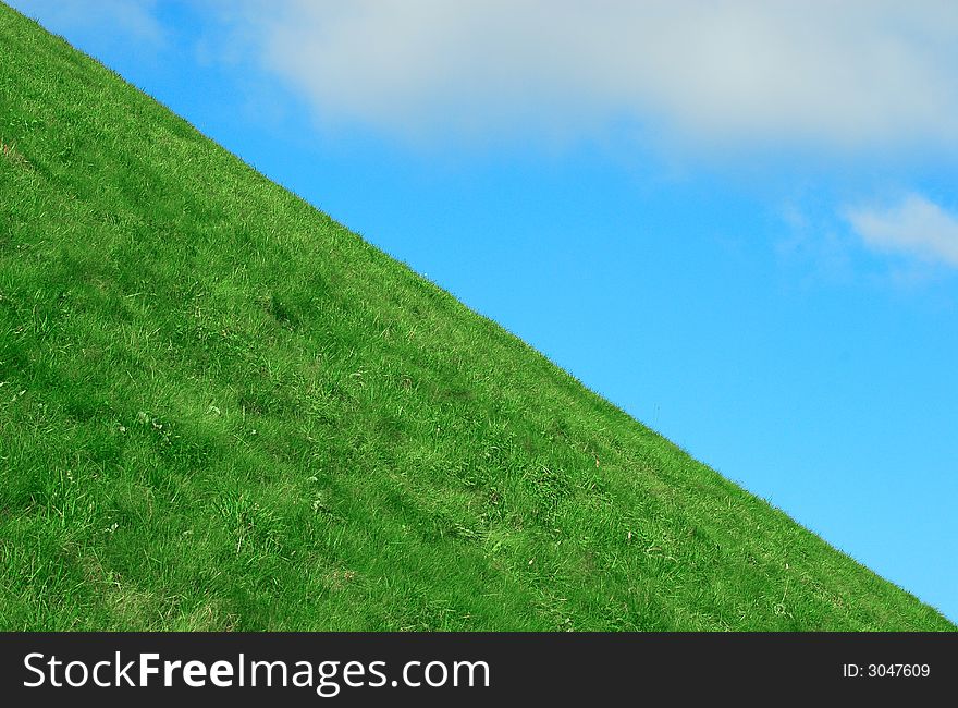 Background the blue sky with clouds and a green grass. Background the blue sky with clouds and a green grass