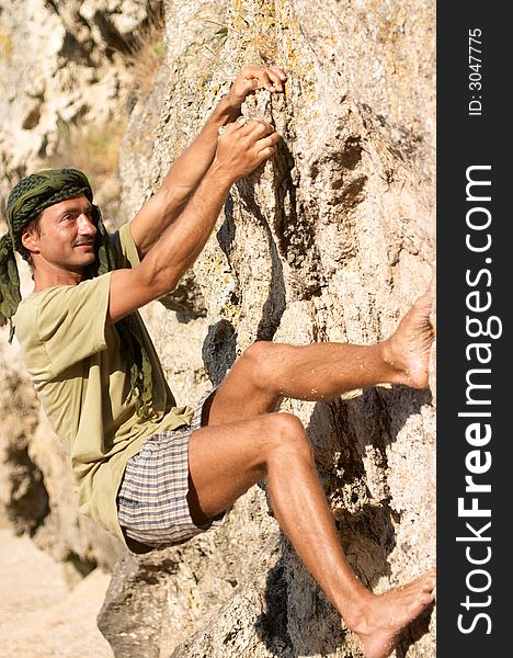 Rock climber man is climbing a very steep rock