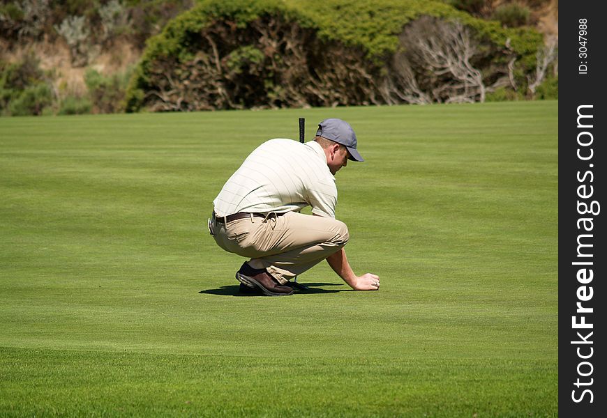 He is aligning his putt, maybe even praying that he sinks this one. He is aligning his putt, maybe even praying that he sinks this one.