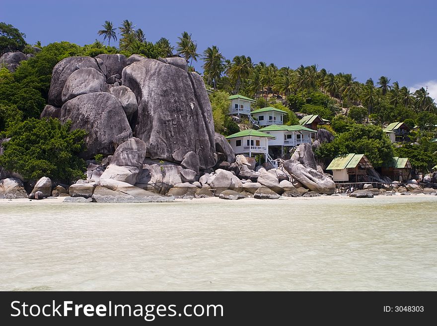 Bungalows between rocks at the thailand ocean beach. Bungalows between rocks at the thailand ocean beach