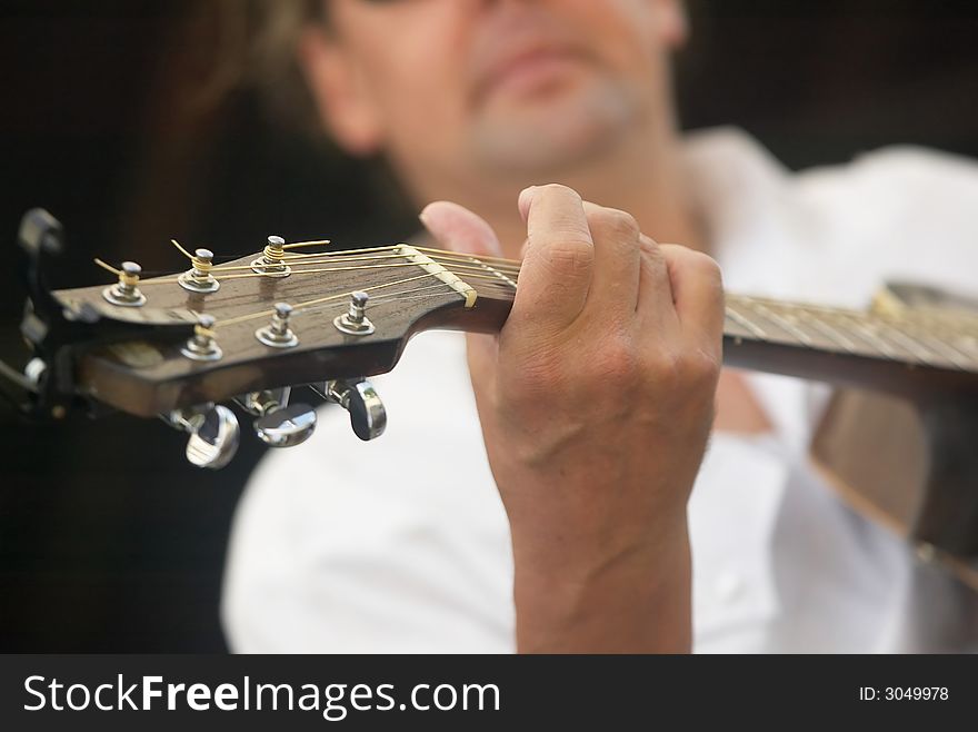 Close-up of a guitar player during a performance. Close-up of a guitar player during a performance.