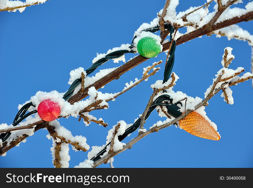 Colorful christmas bulbs covered with snow