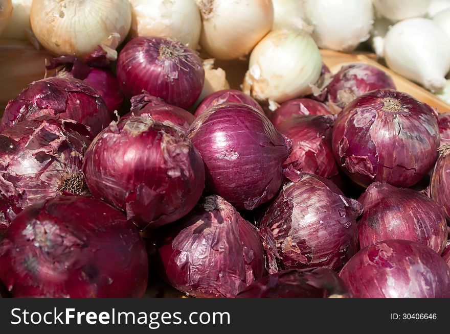 Red and white onions on flea market shelf display