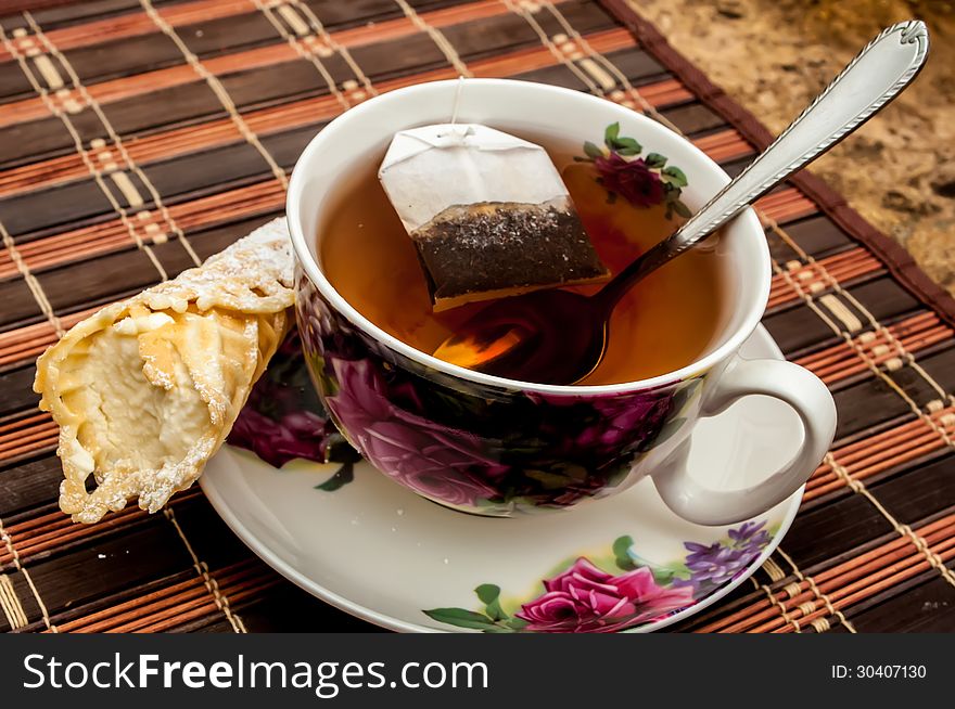 Cup of tea with pastry after dinner on table