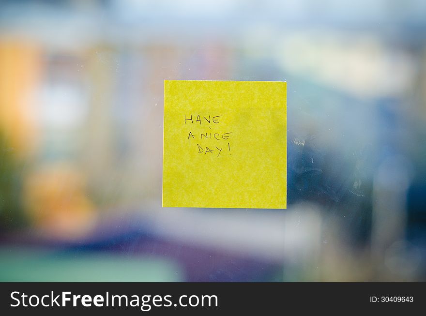 Have a nice day text handwritten on a sticky note against urban background. Have a nice day text handwritten on a sticky note against urban background