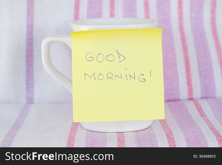 Cup with sticky note Good morning handwritten