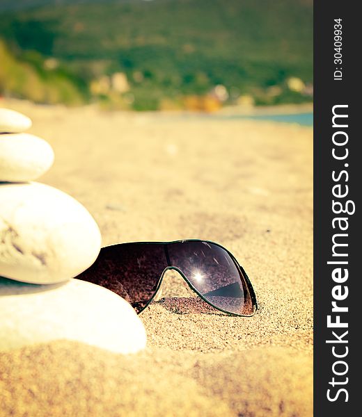 Sea, sandy beach and sunglasses with reflection of the sun. Sea, sandy beach and sunglasses with reflection of the sun