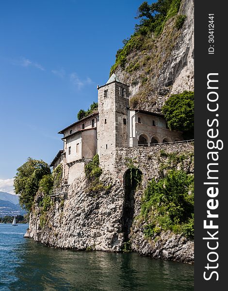 The Santa Caterina Monastery, is perched on a cliff on the edge of Lake Maggiore, Leggiuno, Italy. The Santa Caterina Monastery, is perched on a cliff on the edge of Lake Maggiore, Leggiuno, Italy