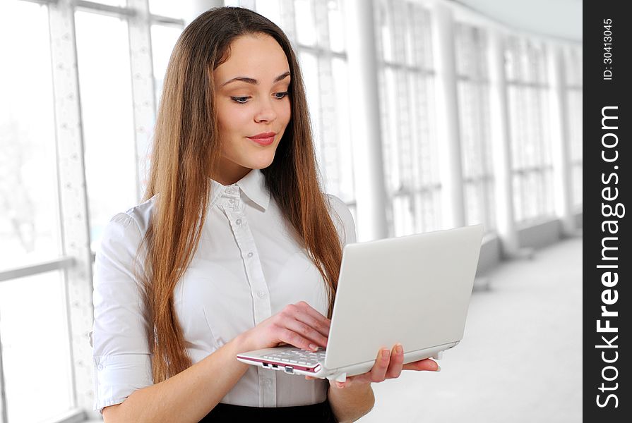 Young business girl with a notebook in hand in the office