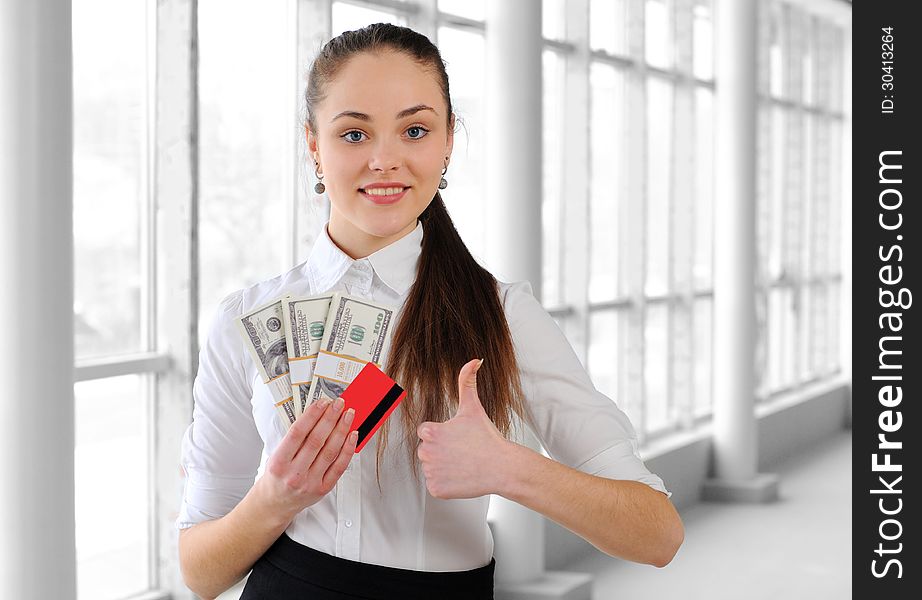 Portrait of a young business girl with money in the office