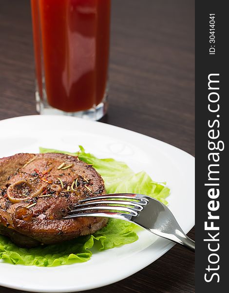 Eating Grilled Steak With Knife And Fork On White Plate