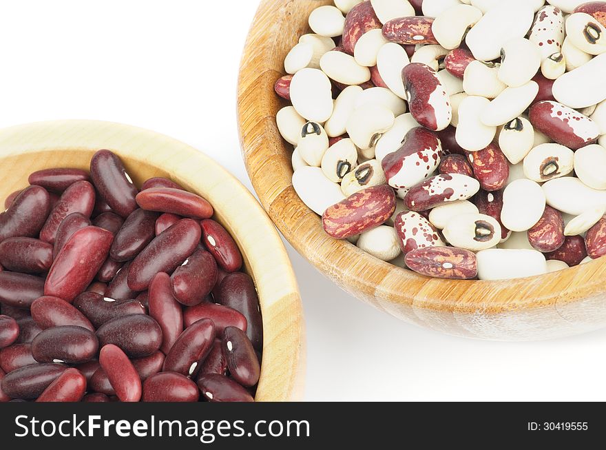 Two Wooden Bowls with Red, White and Variegated Bean on white background. Top View. Two Wooden Bowls with Red, White and Variegated Bean on white background. Top View