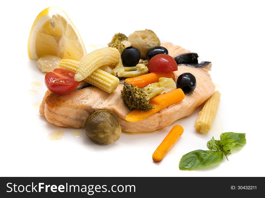 Grilled salmon and boiled vegetables on a white background