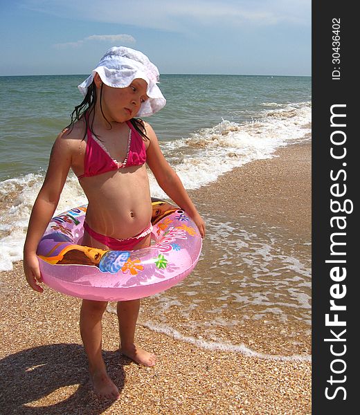 Little girl plays at the sea