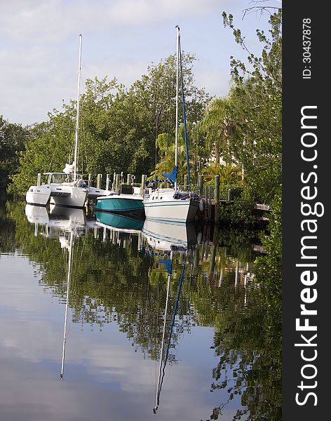 Sailboats rest in a peaceful canal in Key Largo Florida. Sailboats rest in a peaceful canal in Key Largo Florida