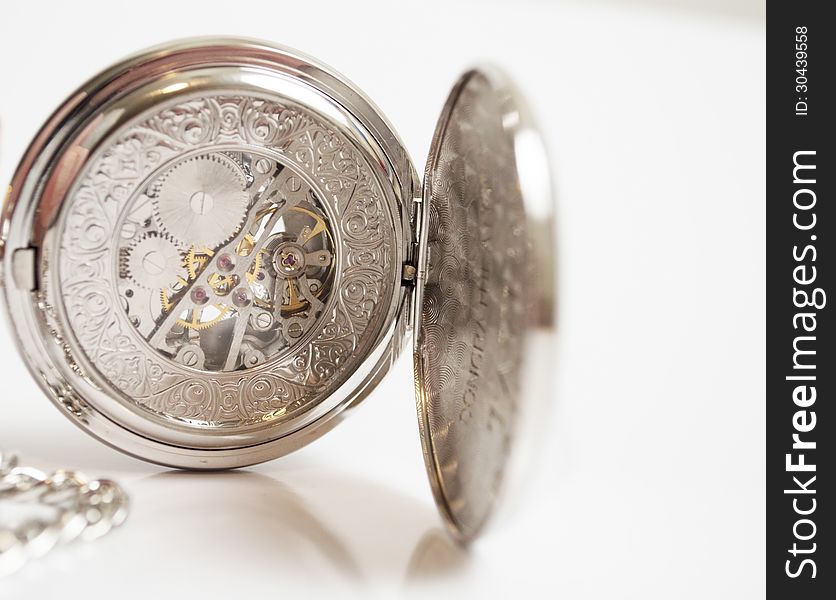 Silver pocket watch with white background