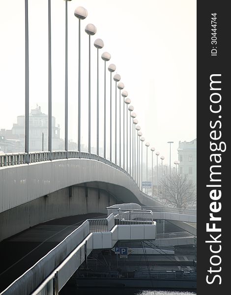 A bridge crossing the danube-river in Vienna Austria, seamed with high poles bearing lantern in the form of spheres. The impression that the distance between the poles is very short is due to the using of a lens with long focal length. A bridge crossing the danube-river in Vienna Austria, seamed with high poles bearing lantern in the form of spheres. The impression that the distance between the poles is very short is due to the using of a lens with long focal length.