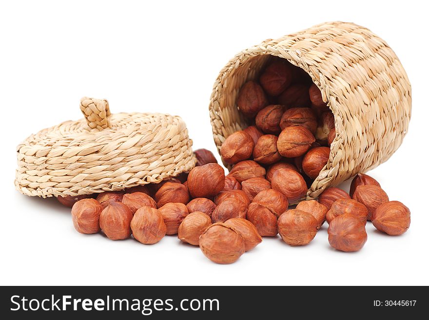 Hazelnuts and basket on white