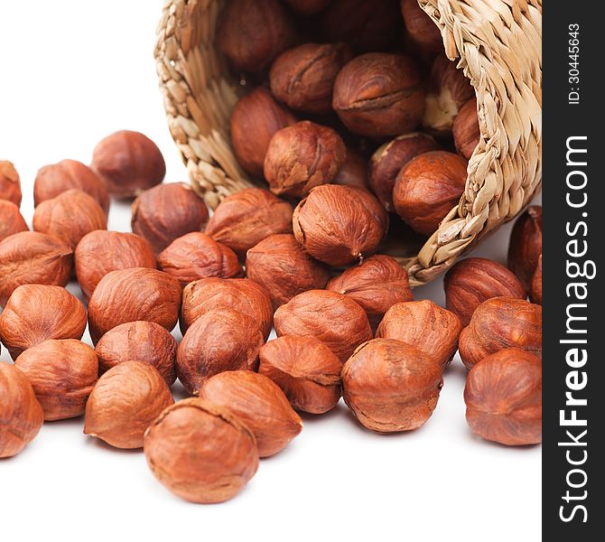 Hazelnuts and basket on white