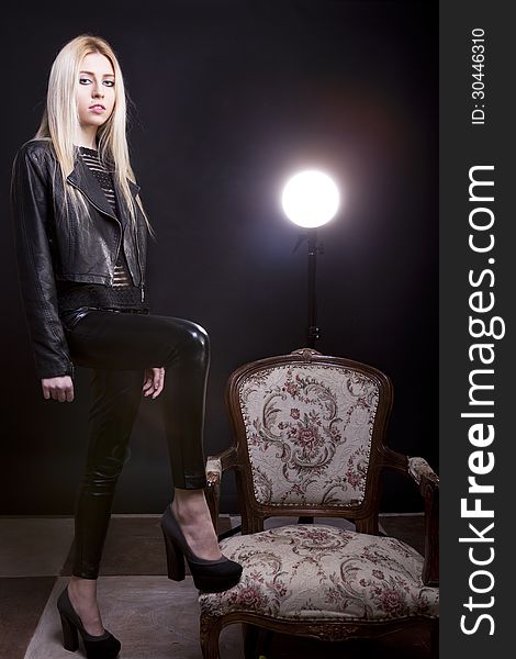 Sensual Blonde With A Leg On A Vintage Chair And A Studio Light