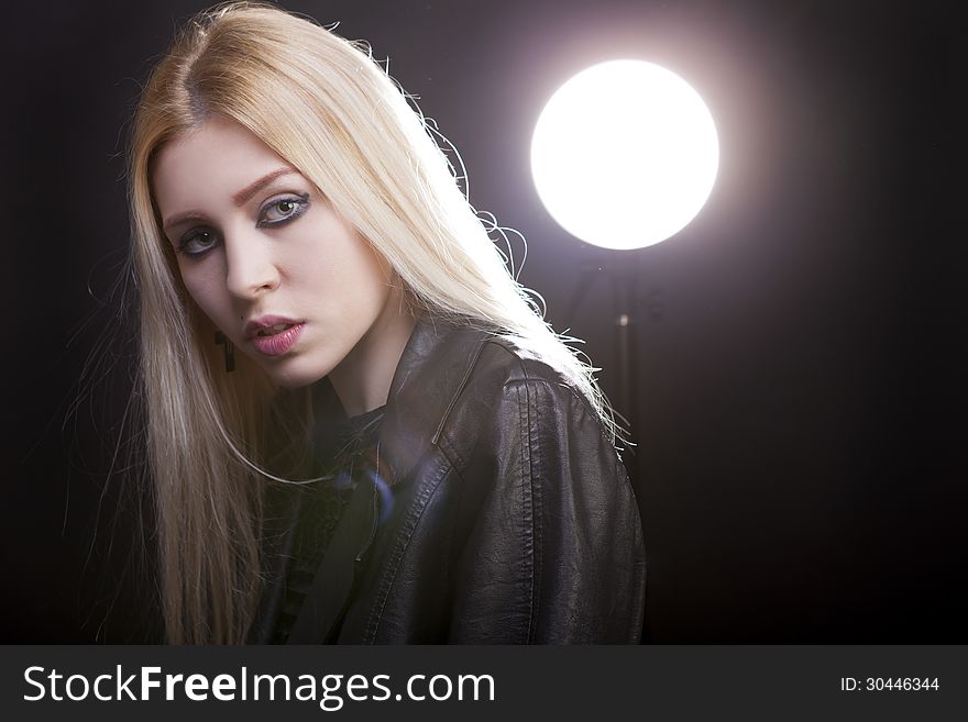 Beautiful blonde with a studio light behind and lens flare studio shot