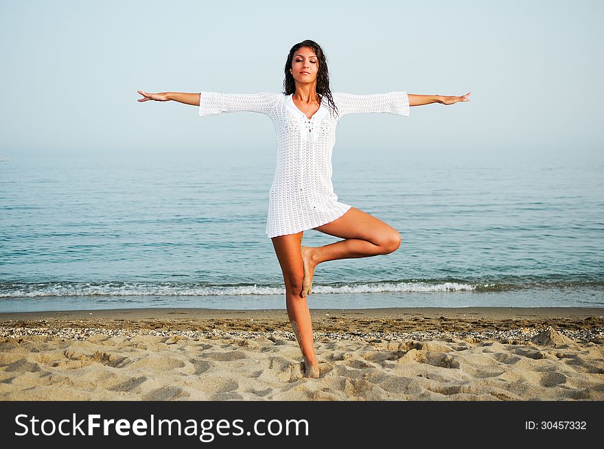 Pretty Woman Doing Yoga On The Beach