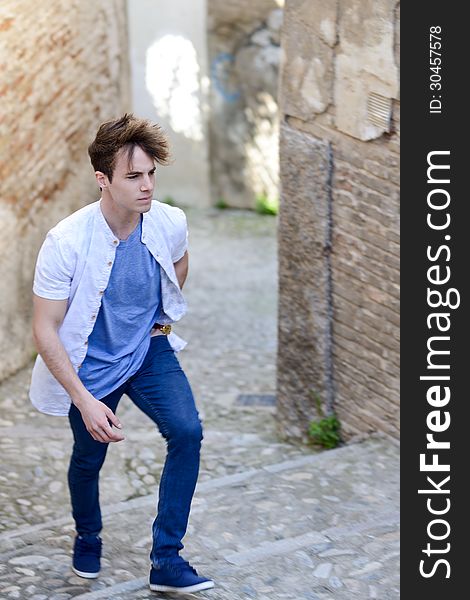 Portrait of attractive young man walking in urban street. Portrait of attractive young man walking in urban street