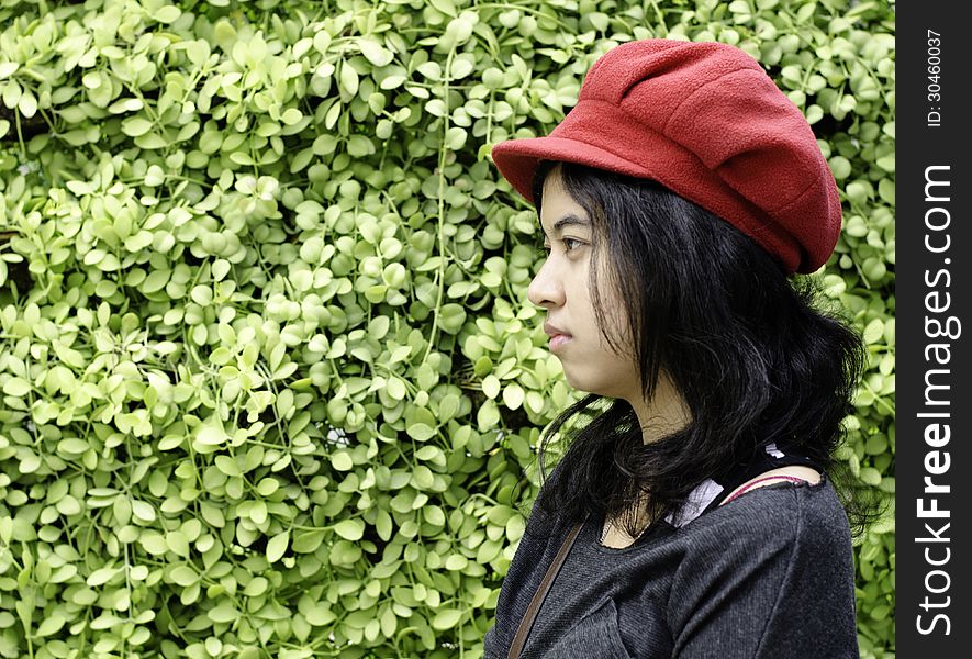 Asian girl with red hat in park on a background of green nature