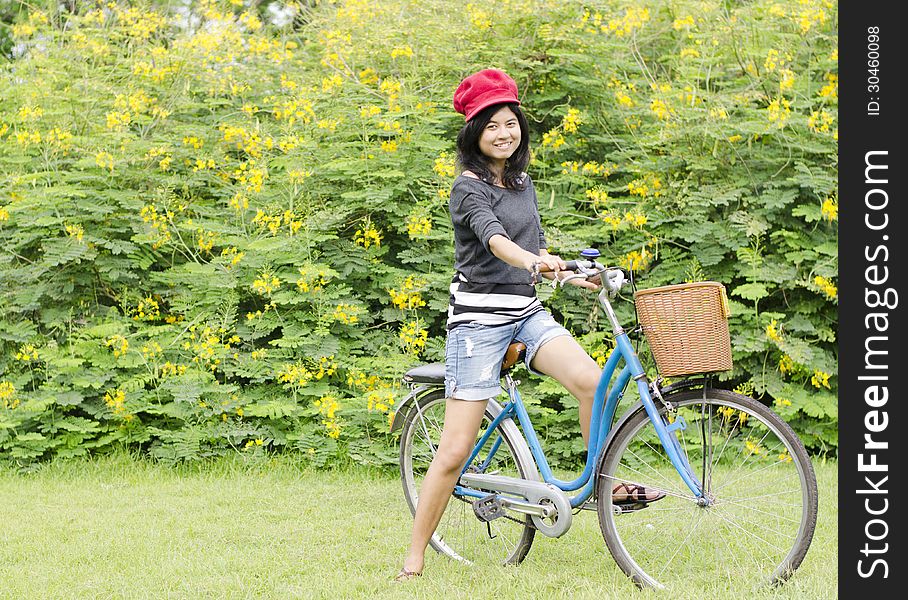 Young Woman On A Green Meadow With A Bicycle
