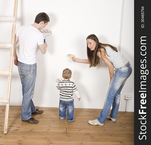 Portrait of happy family doing repair, parents with their son near ladder