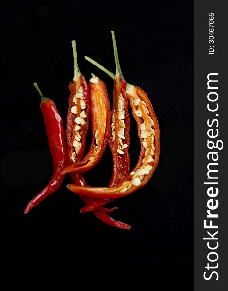 Dissected chillies showing seeds on a black background. Dissected chillies showing seeds on a black background